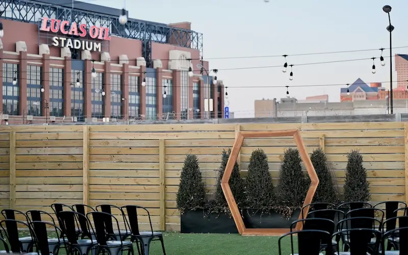 green lawn with wedding seating, lucas oil stadium in background.